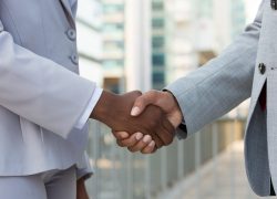 Multiethnic leaders greeting each other in city. Closeup of business man and woman shaking hands outside. Cooperation concept