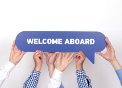 Group of people holding the WELCOME ABOARD written speech bubble